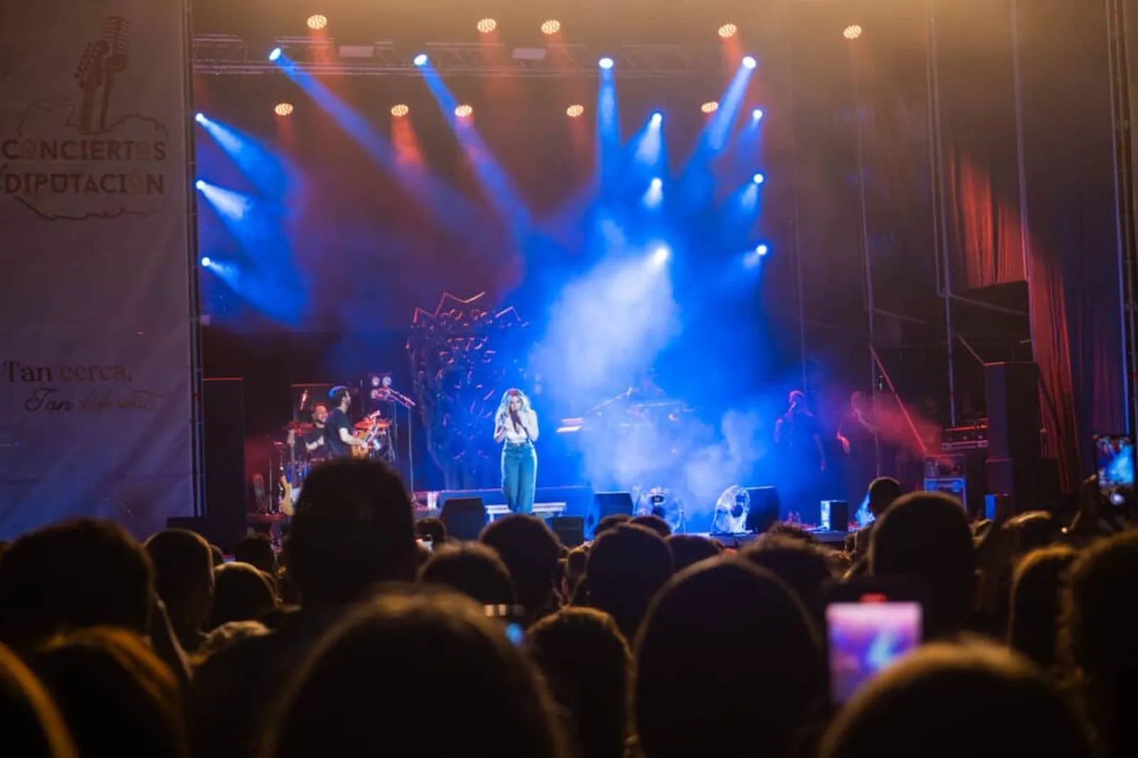 Cantante actuando ante el público en un escenario iluminado