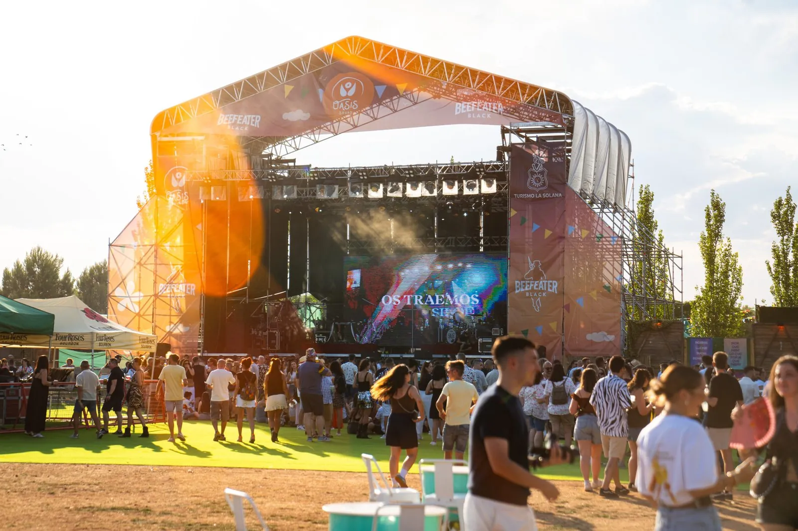 Público de un festival frente al escenario principal al atardecer