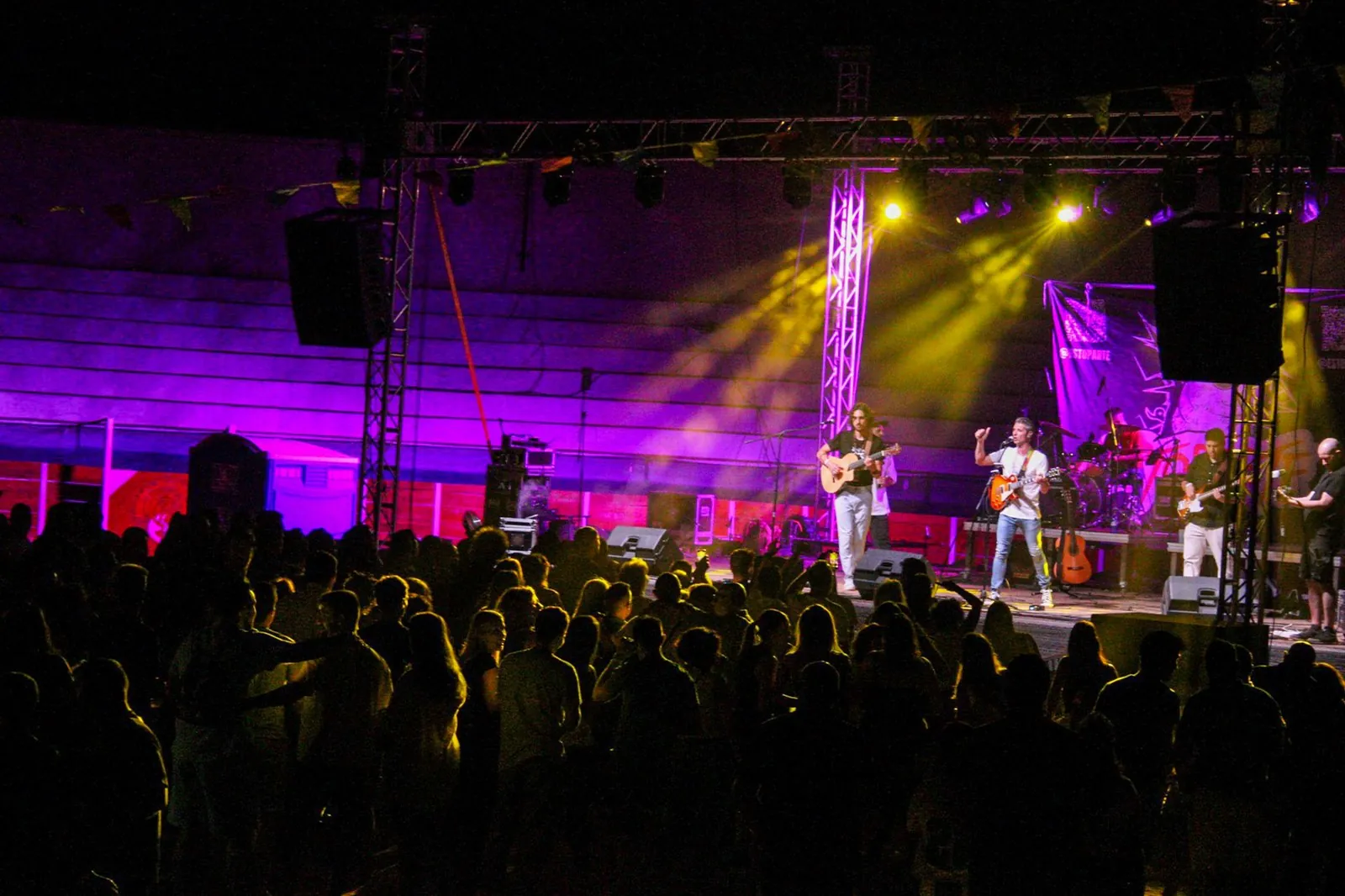 Escenario iluminado con focos de colores durante una actuación